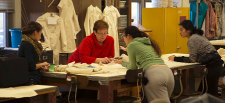 Suzannah Emerson, Old Fort Niagara's music coordinator, left, and Marilyn Deighton, Niagara University associate professor, center left, work with students who are sewing waistcoats.