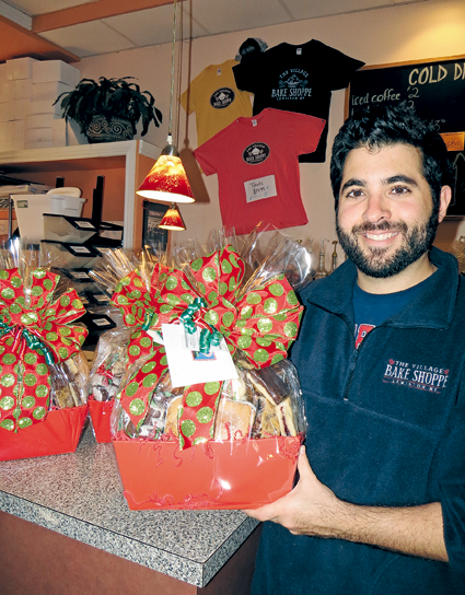 The Village Bake Shoppe's Mike Fiore holds one of his store's holiday baskets. Starting next week, "We switch gears from pies and all of our Thanksgiving desserts to jumping right into our Christmas baskets, cookie trays - shipping those out for our commercial customers all over the country," he said.