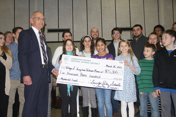 Youngstown Mayor Raleigh Reynolds accepted a check for $5,300 from the Lewiston-Porter students at Tuesday's meeting. The funds will be used to repair the Veterans Memorial in Youngstown that was ruined by vandals earlier this year. Students raised the funds by selling wristbands. The Kiwanis Club of Lewiston matched the amount. (Photo by Janet Schultz)