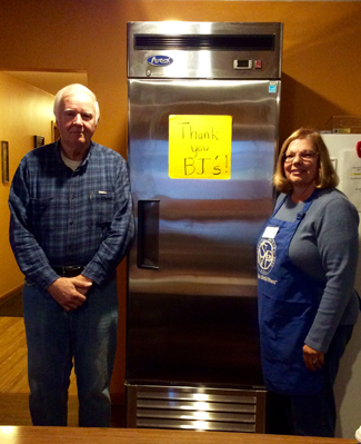Divine Mercy Food Pantry volunteers Stan Krajkowski and Kathleen Camcemi stand in front of their new refrigerator.