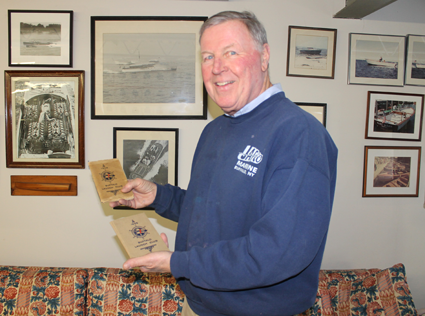 Buffalo Launch Club member Tom Frauenheim holds two club rosters, one from 1905 and one from 1908. These are among artifacts collected by the late Roswell Pfohl, former club member and historian. Contractor Paul Lunick found the documents last year while he was doing a barn demolition and clean out at Pfohl's former East River Road residence. (Photo by Karen Keefe)