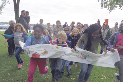 Children break through a paper banner to start the 2015 CROP Walk.