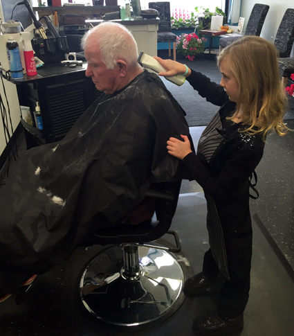 Eden Fancher cuts the hair of her grandfather, Dayton Fancher, a veteran, on Veterans Day. (Photo by Cathy Fancher)