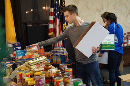 Josh Schaefer, DECA member, was one of 33 students from the school district to volunteer for the Neighbors Foundation at the Knights of Columbus Mary Star of the Sea Council hall.
