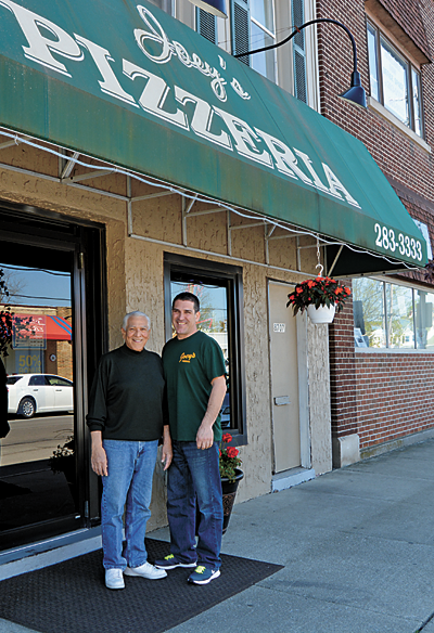 Joseph Previte, owner of Joey's Pizzeria, stands with his son, Mark, in front of his business on Buffalo Avenue. The two recently hung new flower baskets in front of the business.