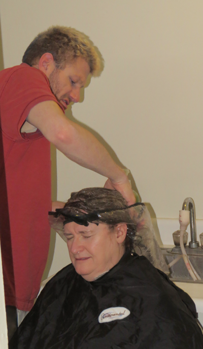 Lori Cooper receives free hair styling from Brian Palmer.