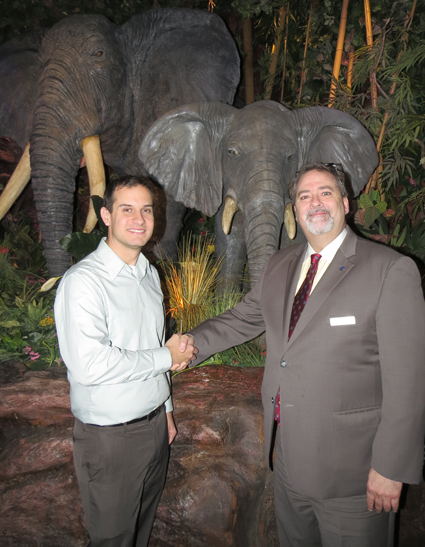 Community Missions Communications and Development Manager Christian Hoffman, left, shakes hands with Geoffrey Reeds, executive director of sales and marketing for Sheraton at the Falls. Guests are invited to dine at the Rainforest Café, pictured, on #GivingTuesday, when a portion of the proceeds will be donated to CMI.