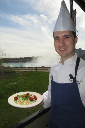 Top of the Falls Restaurant chef Daniel Thorington holds a plate of Buffalo mac and cheese.