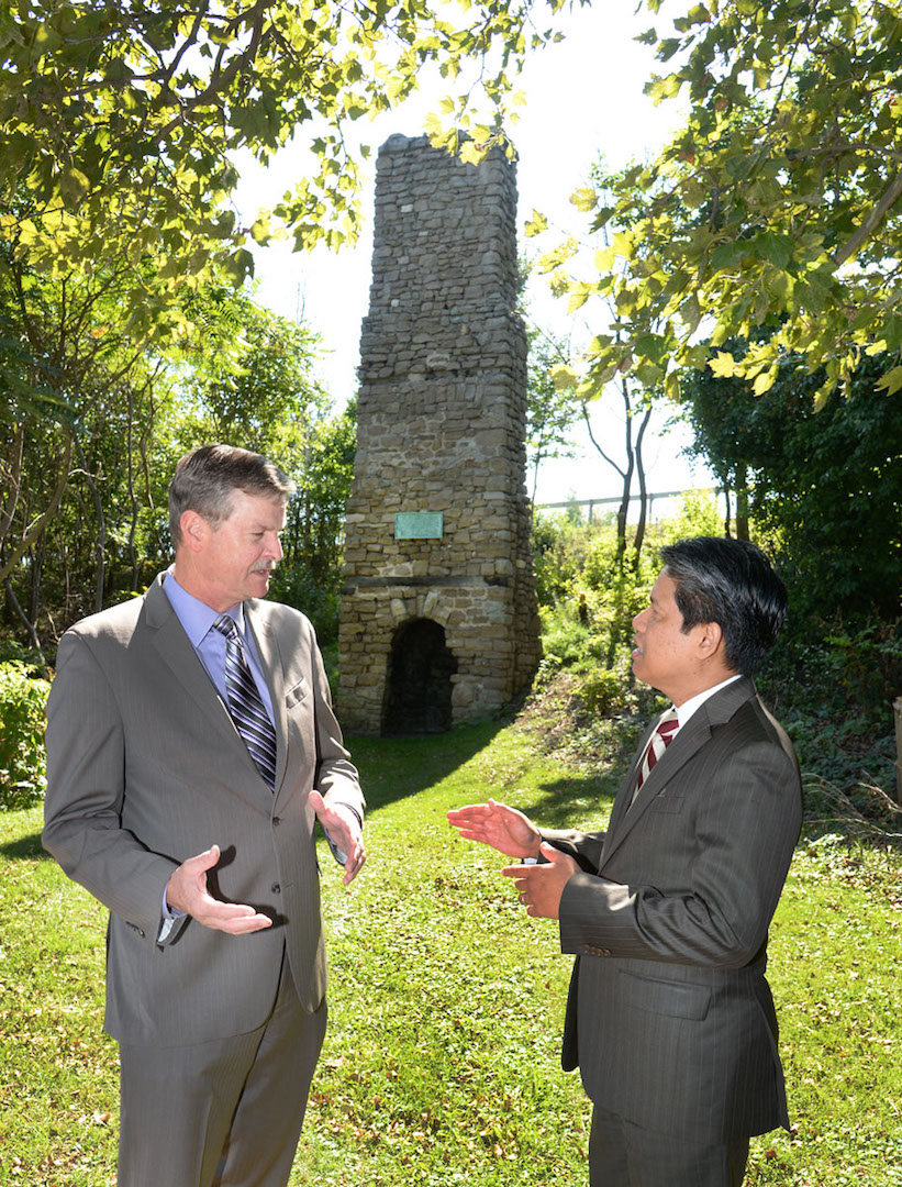 Mayor Paul Dyster, left, and Gil C. Quiniones, president and CEO of the New York Power Authority, stand in front of the Old Stone Chimney and discuss NYPA's plans to relocate the monument closer to the Niagara River to enhance public access. Located on NYPA property, the chimney dates back to the mid-18th century and was once part of French and British forts. (NYPA photo)