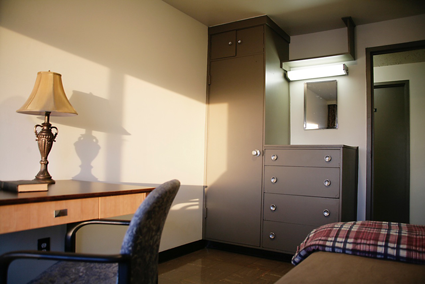 The standard room at Portage Road is furnished with a bed, desk and built-in wardrobe/dresser.