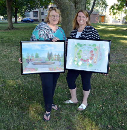 Co-chairs of the children's memorial project MaryBeth Kupiec (left) and Paula Benedyczak hold up two renderings of the garden. Landscape architect Frank Brzezinski designed the memorial. 
