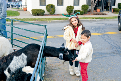 Elise and Owen Rambally help feed the animals at the petting zoo outside the YWCA.