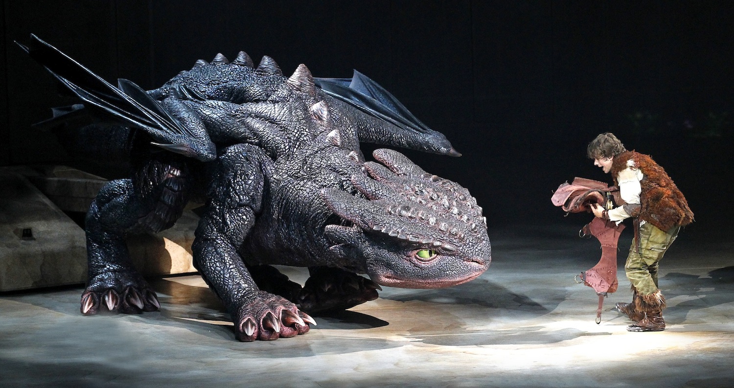 Hiccup (Rarmian Newton) fixes Toothless' tail. (photo by Jeff Busby)