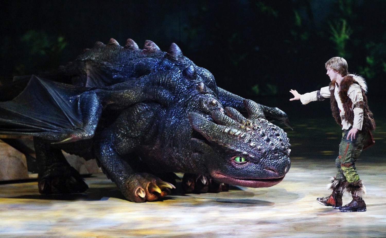 Hiccup (Riley Miner) tames Toothless. (photo by Todd Kaplan)