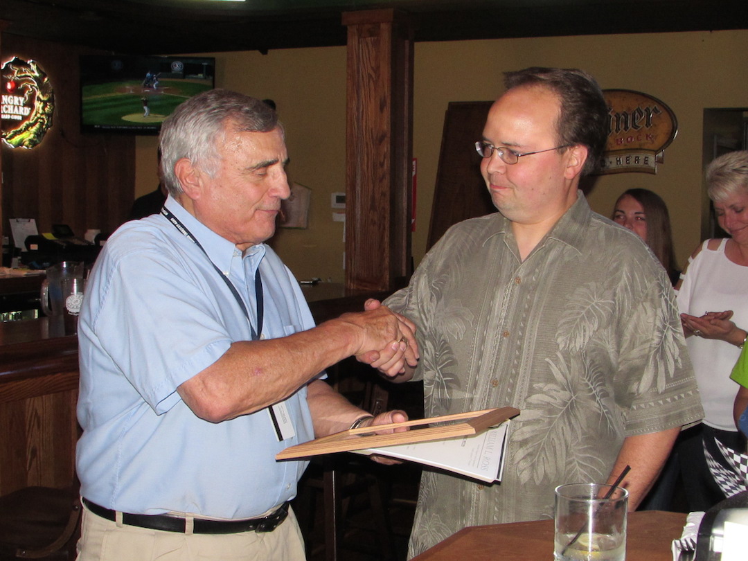 Niagara County Legislator Chairman William Ross, left, presents Chris MacKenzie with a plaque signifying the opening of Bailey O'Riley's Village Pub.