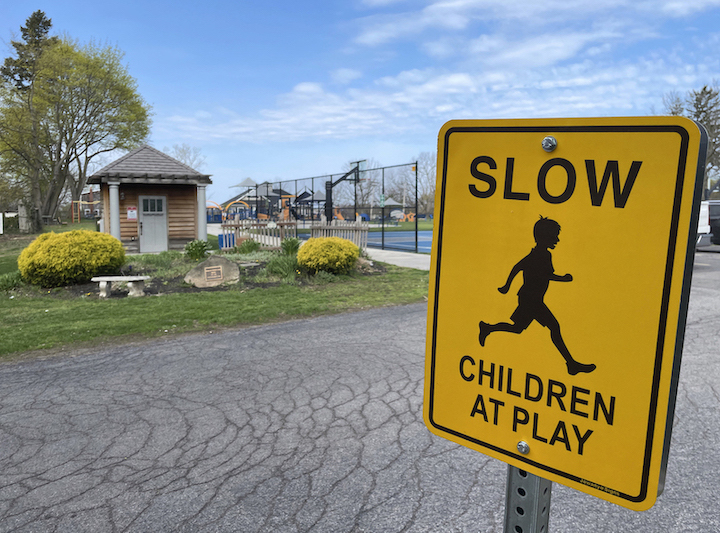 A sign in front of the inclusive playground at Marilyn Toohey Park encourages motorists to  drive slow, as children are at play.