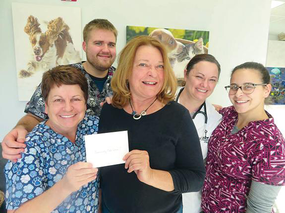 Presenting a check to Community Cats Alive: From left, Kelley Casale, Tyler Mayers, Kathryn Serianni, Dr. Kristen Ruest of the Village Vet and Kristianne Casale.