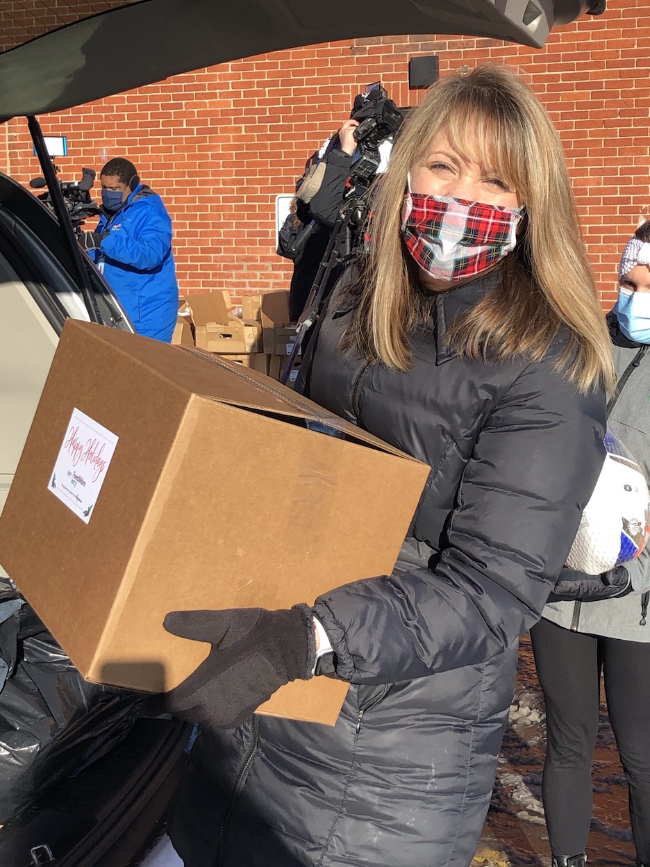 Wegmans Consumer Affairs Manager Michele Mehaffy loads a holiday food box into a client's vehicle at Gerard Place.