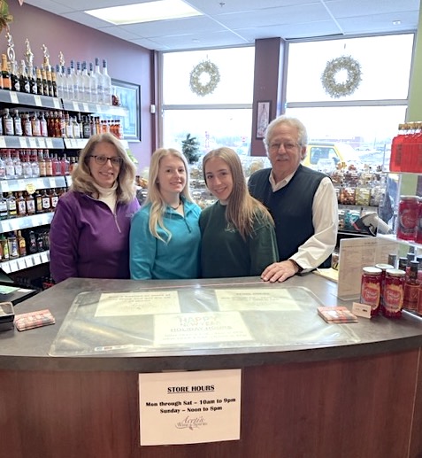 The Aceti family stands behind the counter at Aceti's Wine & Spirits. From left are Kim, Melina, Marissa and Sam Aceti. Sam and Kim sold the business last month to Andrew Graziano and Peter Johnson, who have renamed the business as Grand Island Wine & Spirits. (Contributed photo)