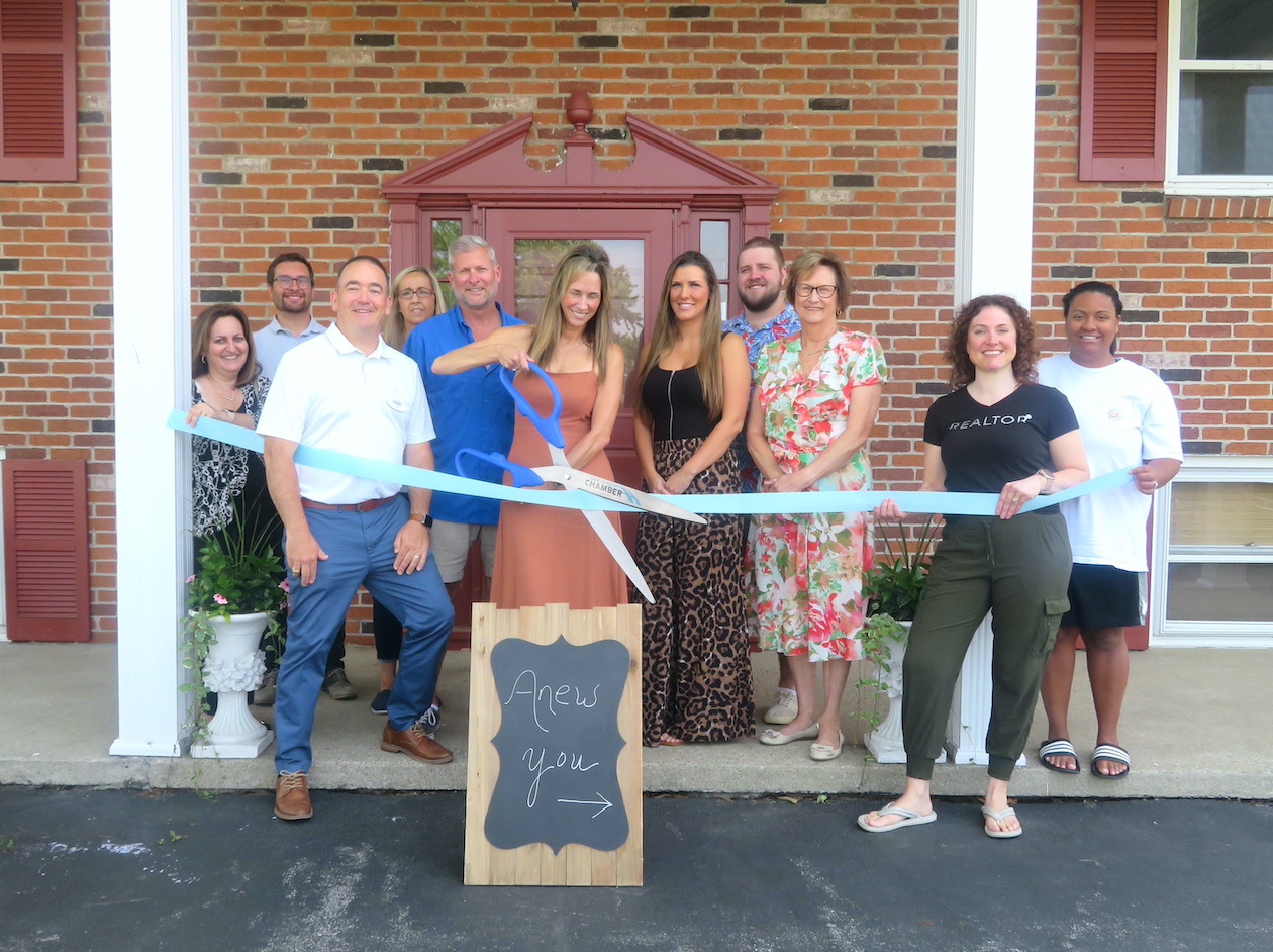 Laura Lewis Mason cuts the ribbon to her business alongside members of the Grand Island Chamber of Commerce.