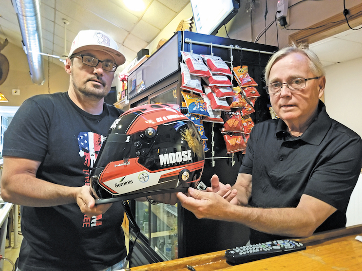 Moose Lodge president Eric Anderson and member Richard Williams show the NASCAR Cup race helmet to be raffled off.