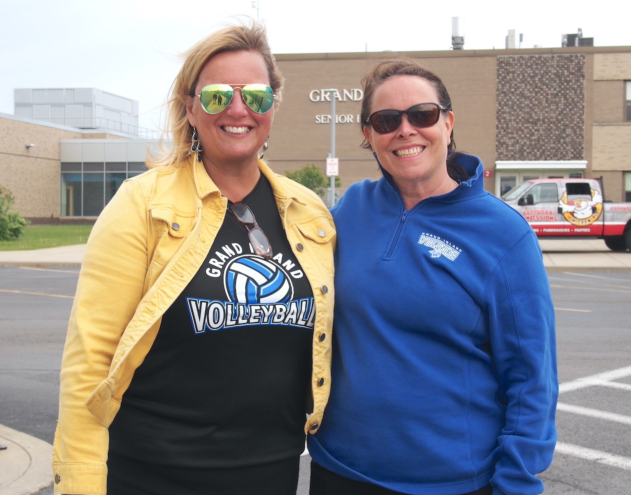 Ashli Dreher and Susan Marston greet voters as they walk to the high school gymnasium to cast their ballots.