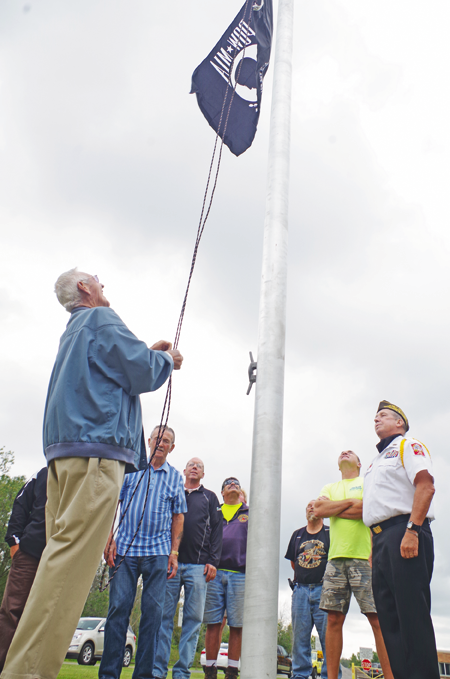 Ray Dlugokinski raises the POW-MIA flag. (Photo by Larry Austin)