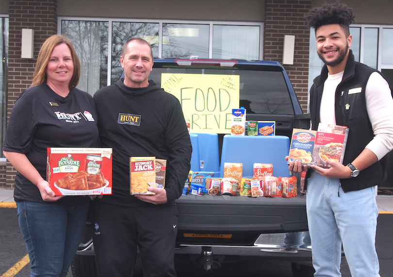 Rebecca Simpson of Hunt Real Estate; Chris Simpson, business teacher at Grand Island High School; and Hector Lopez, also of Hunt Real Estate, show the growing collection of food to be donated to the Neighbors Foundation.