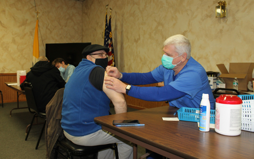 Jack Giardina of the Town of Tonawanda gets his first COVID-19 vaccination Wednesday morning at the Knights of Columbus Hall, 1841Whitehaven Road. One hundred of the Moderna vaccines were administered, with proper social distancing and masks, on Wednesday by Island Prescription Center, 1728 Grand Island Blvd. The pharmacy has administered 700 shots to date. (Photo by Karen Carr Keefe)