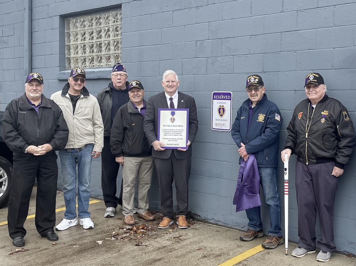Erie County Clerk Mickey Kearns dedicates a reserved parking space for Purple Heart recipient service men and women at the Erie County Auto Bureau in Derby. On hand to assist in the unveiling was Purple Heart recipient James Trembath of the Town of Evans; members of the Military Order of the Purple Heart, Chapter 187; and United States Air Force combat veteran and Town of Evans Councilman Mike Schraft. (Submitted photos)