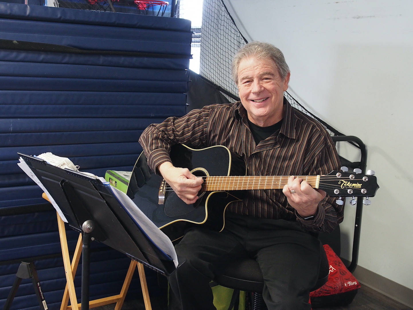 Ray Braselton, who teaches guitar lessons at the Nike Base, serenades visitors to the Community Center.
