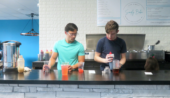 Vinh Nguyen coaches Judah Chapman through the process of making bubble tea and other beverages.