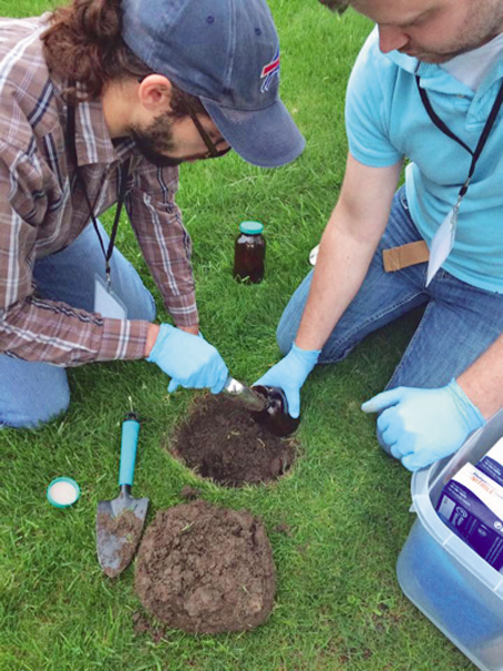 Matthew Falcone, a University at Buffalo student, and Josh Wallace, UB soil testing project manager, take a soil sample. (Pictured courtesy Jackie James-Creedon)