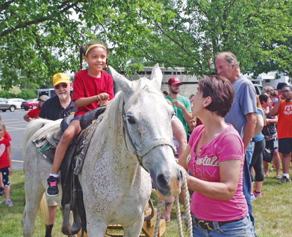 Donna Peffer leads Moriah, a horse from Sparks Trading Post, on a pony ride for one of the hundreds of children at the Grand Island Lions Club Special Kids Picnic. (Photo by Larry Austin)