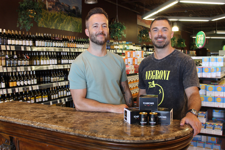 Rob Hopkins, left, and Paul Scappechio, graduates of Grand Island High School Class of 2003, show their canned cocktail, Togronis, which is now offered for sale at Grand Island Wine & Spirits in the Tops Plaza. Scappechio, company co-founder, said the cocktail is patterned after a Negroni, a classic Italian cocktail. Graphic designer Hopkins, owner of Stronghold Studio in Buffalo, handled the branding and packaging of Togronis.
