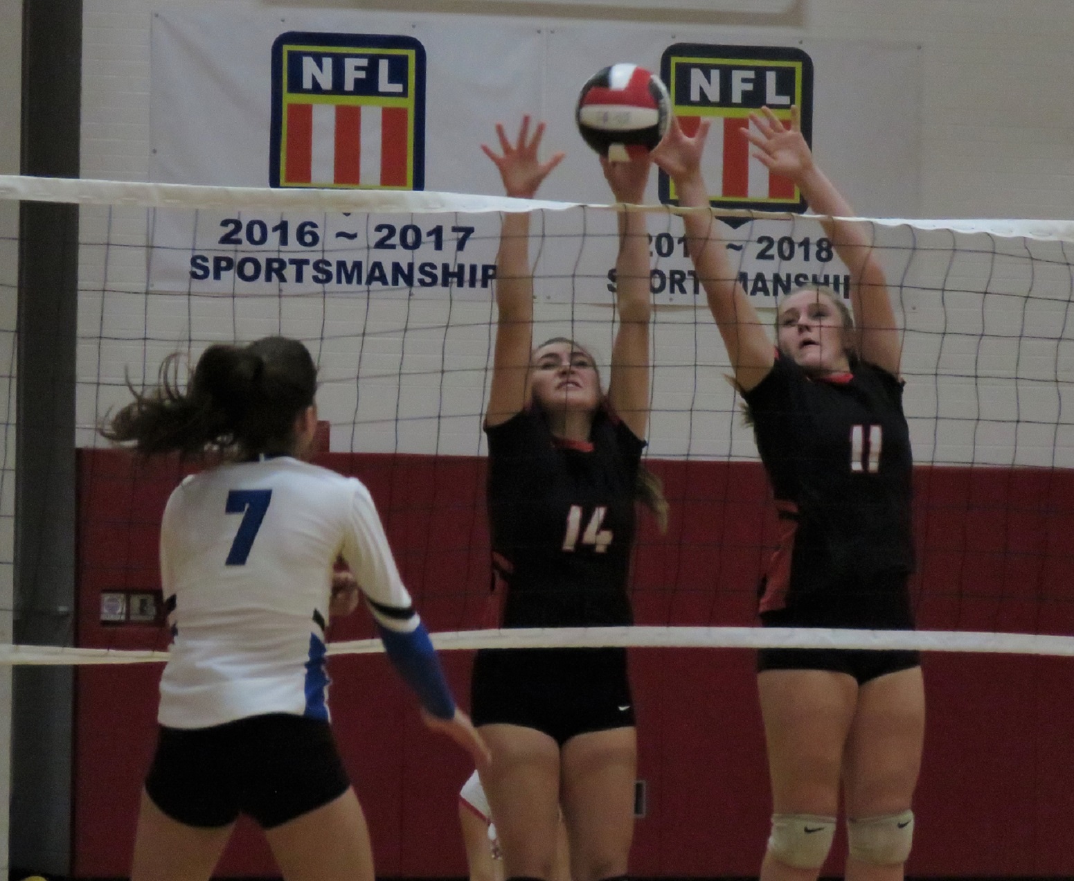Niagara-Wheatfield's Emily Quider (14) and Elanna Lysiak (11) block a spike from Grand Island's Sara Frosolone during Thursday night's victory. (Photo by David Yarger)