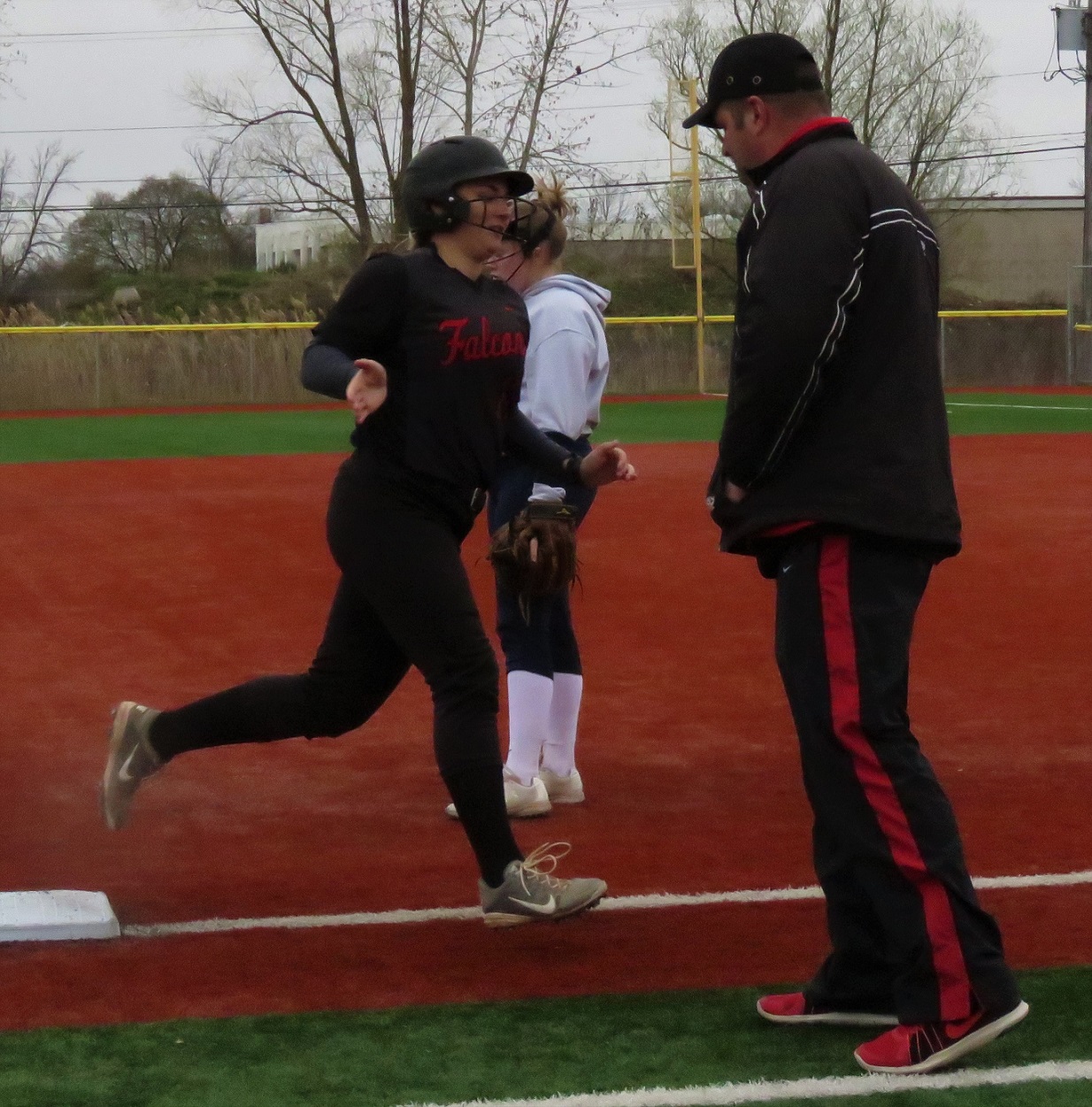 Niagara-Wheatfield's Mackenzie Quider receives a high-five from Falcons coach Jim Proefrock following her second home run versus Niagara Falls. The Falcons used four home runs to defeat the Wolverines, 14-6. (Photo by David Yarger)