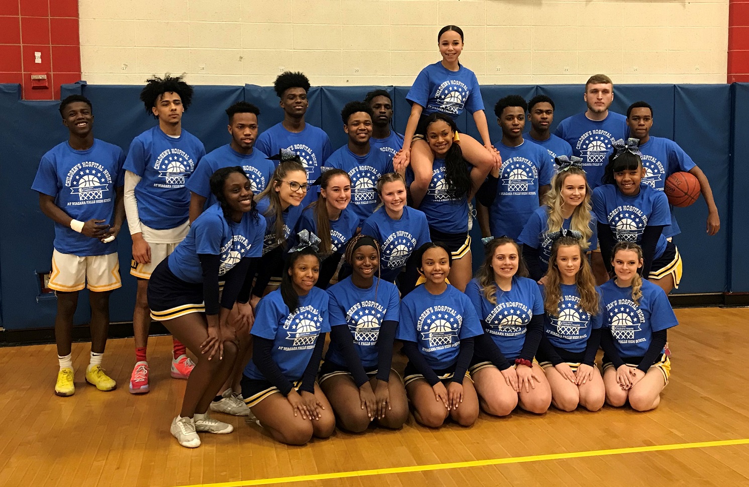Niagara Falls High School cheerleaders and basketball players pose before the game in the Children's Hospital Night-themed blue T-shirts. (Photo by David Yarger) 