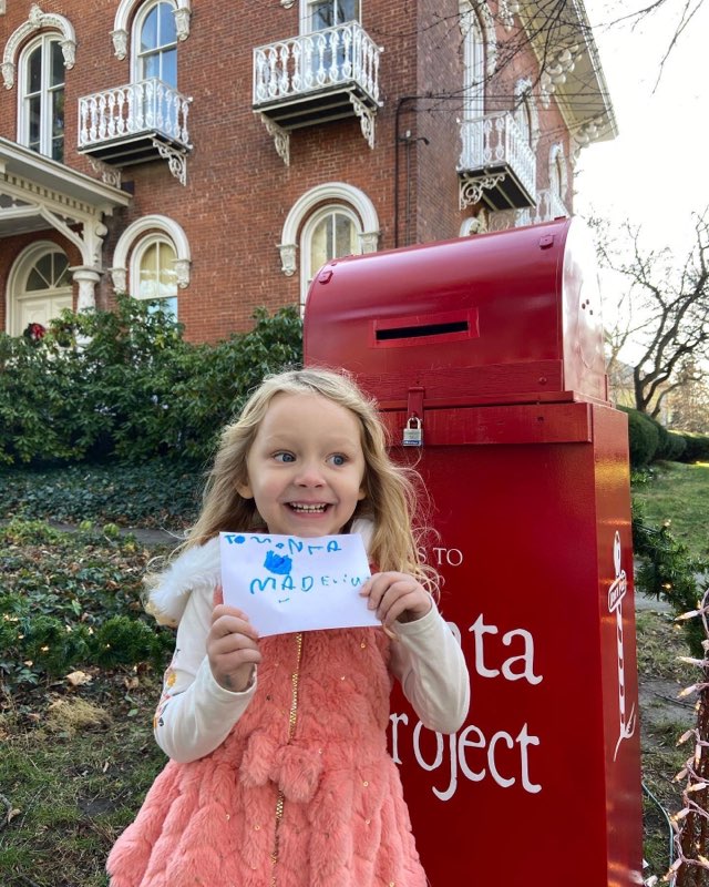 Madeline Herzog holds up her Christmas letter from 2021, moments before dropping it into the `Letters to Santa` mailbox to travel to the North Pole. This special mailbox will be in front of the Kenan House from Nov. 19 through Dec. 18. Santa will personally answer every letter, if a return address is provided. (Submitted photo)