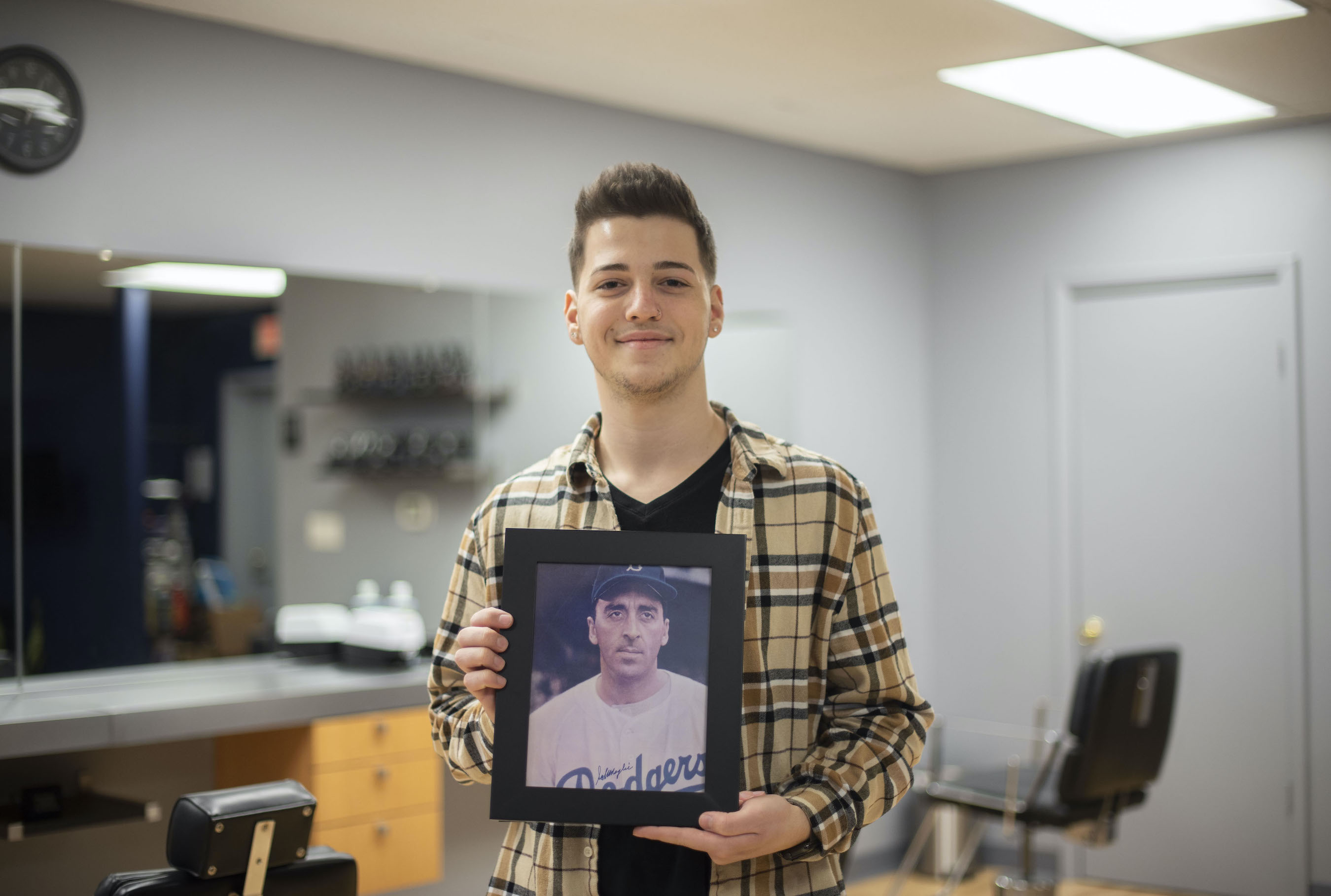 Paolo Beilman is shown with images and memorabilia from his great-great-uncle, former Major League Baseball pitcher Sal Maglie, inside the new `The Barber` Co. located at 2301 Pine Ave., Niagara Falls.