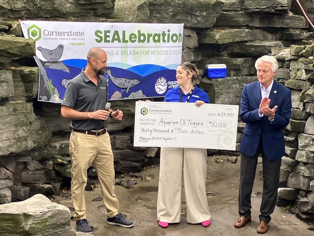 From left: Cornerstone CEO Eric Hepkin presents $30,000 check to Aquarium of Niagara Senior Development Manager Alexandria Lang, as City of Niagara Falls Mayor Robert Restaino looks on.