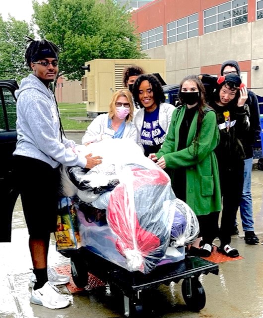 JoAnn Pellegrino is greeted by a group of NFHS students to receive the donated dresses.