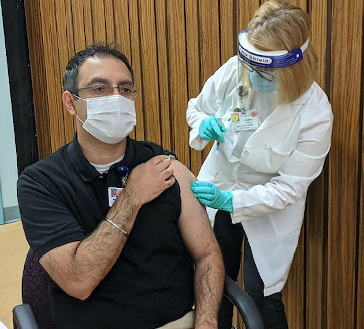 Dr. Rajinder Bajwa, chief of the infectious disease division at Niagara Falls Memorial Medical Center, receives a COVID-19 vaccine shot.