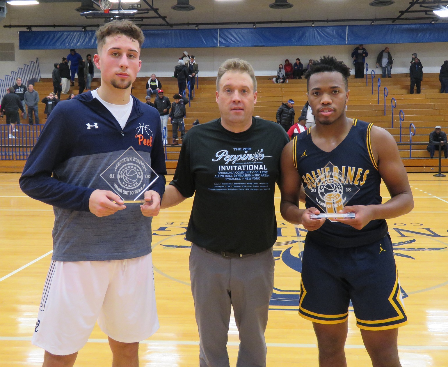 Niagara Falls' Josiah Harris (right) poses after winning Player of the Game honors after the Wolverines' 71-42 victory over Liverpool. Harris scored 11 points, including three 3-pointers. (Photo by David Yarger)