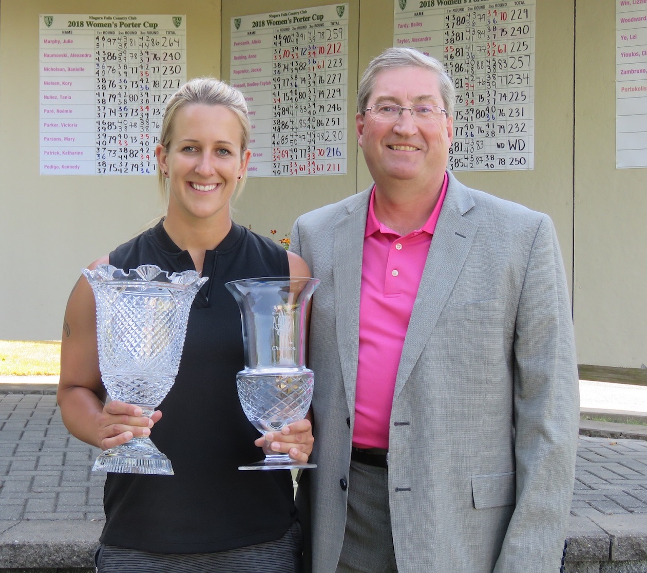 Zoe-Beth Brake holds her winning trophies alongside Tournament Director Brian Oakley. (All photos by David Yarger)