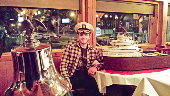 Justin Higner poses with part of his sculpture model of the SS Edmund Fitzgerald.