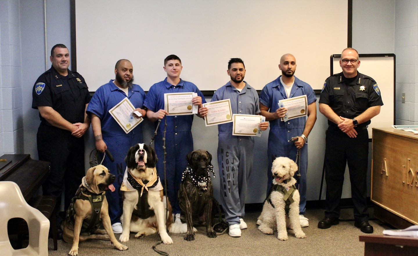 Inmates seen in the photo have trained the dogs for the `Pawsitive for Heroes` program. The service animals are given to local vets in need.