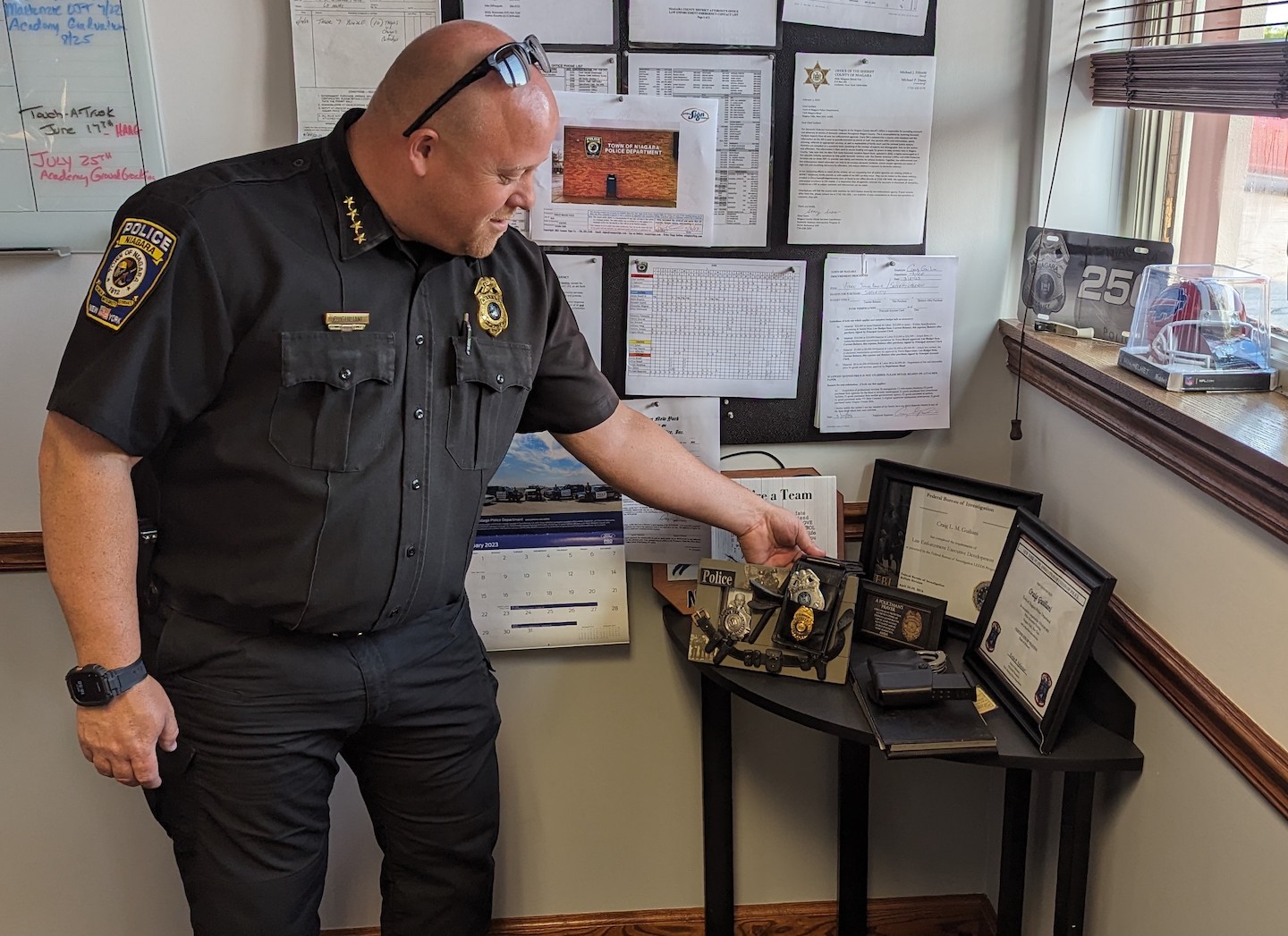 Town of Niagara Police Chief Craig Guiliani admires his great-grandfather's police badge, which sits as part of a display of family members' accomplishments in the department throughout the years. Guiliani was named the town's next chief, a title he's held in interim since September, at Wednesday's Town Board meeting.