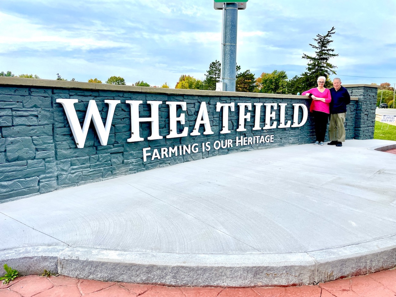 Wheatfield welcome: Rita and Tom Kontak of the Wheatfield Enhancement Volunteers stand by the Wheatfield wall at Nash Road and Niagara Falls Boulevard. That wall, completed in the fall of 2022, is part of a project that will include two future walls at the Ward Road and Witmer Road intersections with Niagara Falls Boulevard. Ward Road's wall will feature a farming motif, while the Witmer Road wall will highlight the contributions made by the former Bell Aerospace. The project goal is to ensure that thousands of residents, commuters and tourists know they are passing through the Town of Wheatfield. The second two walls are expected to be completed by end of this year. The New York State Department of Transportation is working on intersectional revitalization projects at Ward and Witmer, too. This will add turning lanes to all four points of both intersections and improve the safety of travel along the corridor. (Contributed photos)