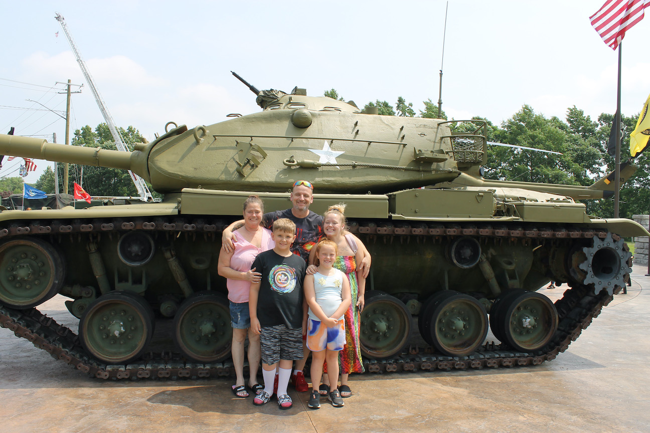 The family of Dechend Bateman and Adam Kusmierski poses in front of a tank at the Wheatfield veterans summer event on Saturday. The children are, from left, Kingston Kusmierski, 10; Maya LoCocco, 8; and Brooke Turner.